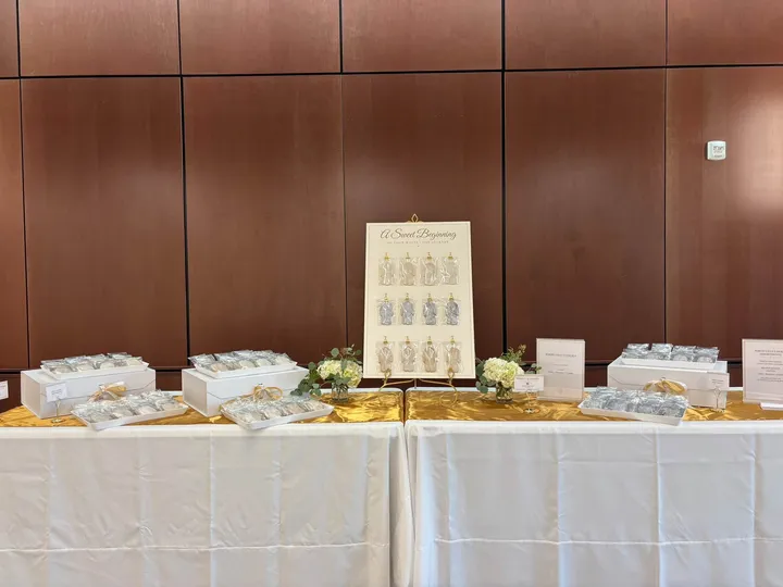 Individually wrapped custom cookie favors displayed on a gold-draped table
