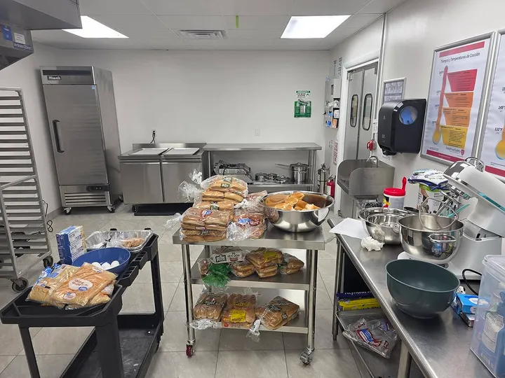Kitchen counter stacked with donated bread loaves and mixing bowls