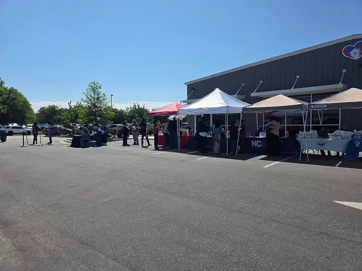 Rows of vendor tents set up in a parking lot for a community resource fair