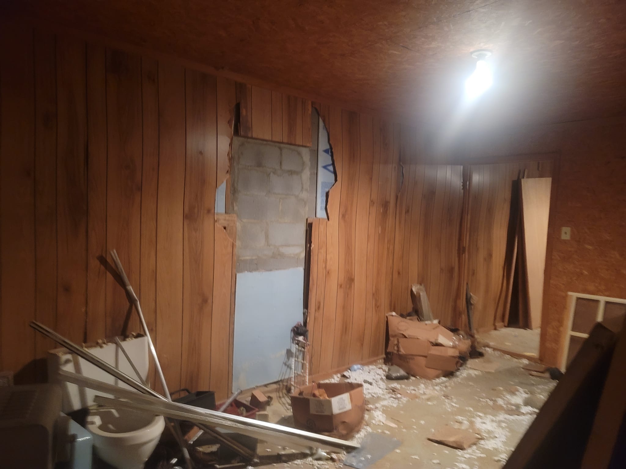 A room during renovation with paneling pulled back to the block