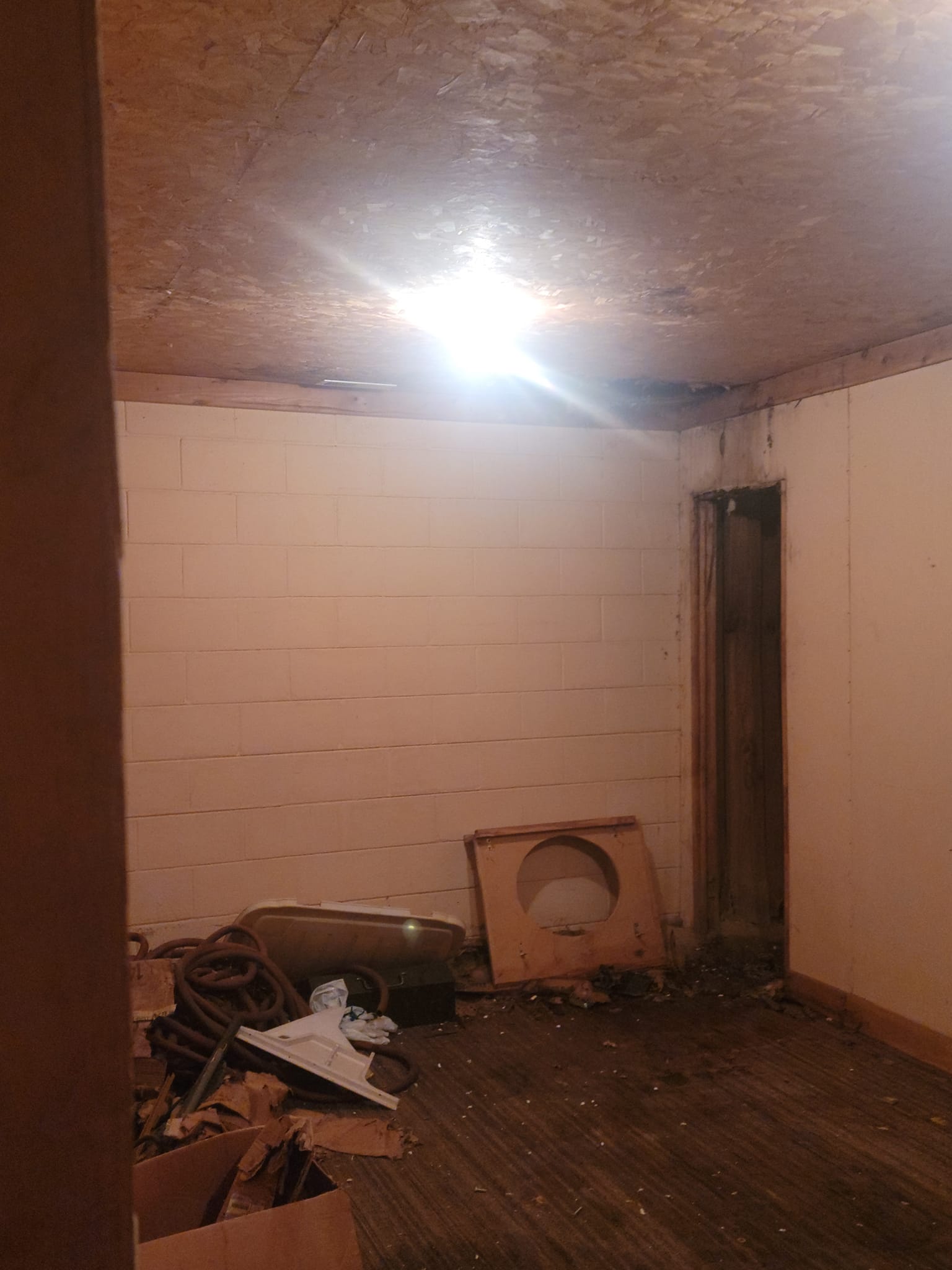 A stripped room of bare block and open subfloor before it became a kitchen